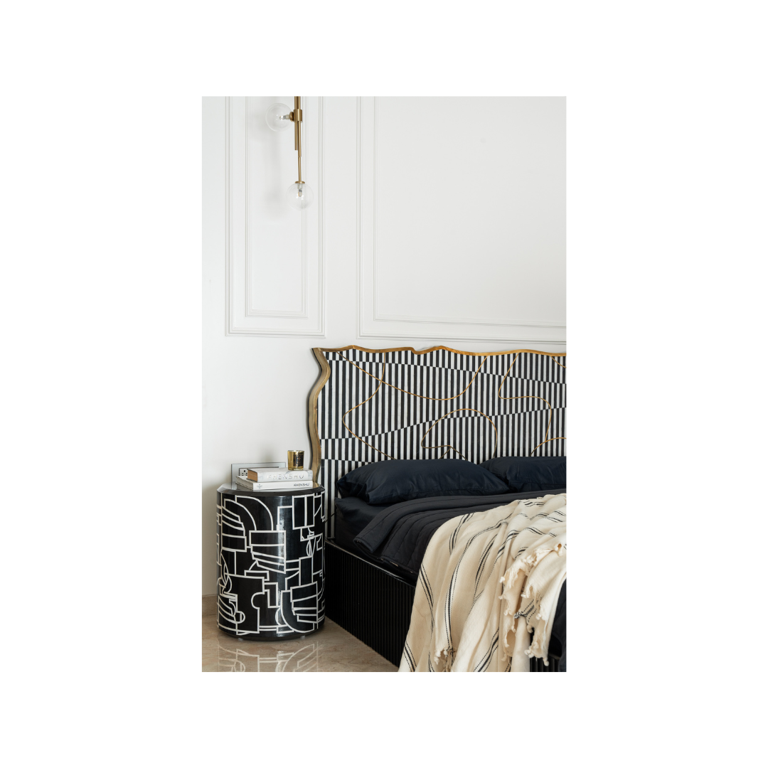 Abstract Picasso side table beside striped headboard bed