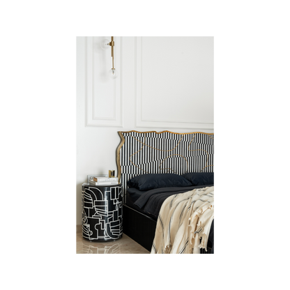 Abstract Picasso side table  beside striped headboard bed 