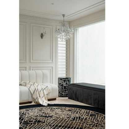 Madrid Rug handcrafted round black and beige abstract map rug in elegant living room with cream sofa
